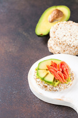Crispbread with avocado and a salmon against a dark background. Selective focus. Copy space