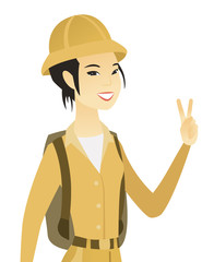 Young asian traveler showing victory gesture.