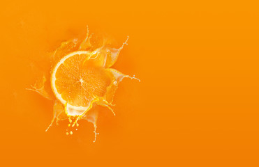 Slide cut piece of orange drop on orange background with orange juice splash water with copy space