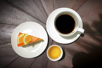 Coffee with orange cake on wood background
