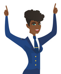 African stewardess standing with raised arms up.