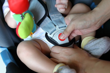 baby child sitting in car seat with safety belt locked protection