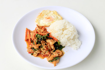 stir fried chicken with roasted chili paste and fresh Piper nigrum on jasmine rice in white plate on white background. Thai style food.