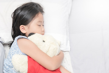 cute little asian girl sleep and hug doll