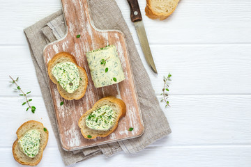 Sandwiches with herbs butter On Cutting board on white wooden background