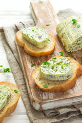 Sandwiches with herbs butter On Cutting board on white wooden background