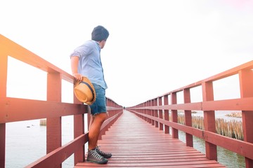 Asian travel man on wooden bridge, Summer travel with copy space