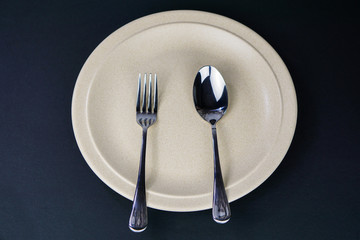 Plate , fork and spoon  isolated on black background