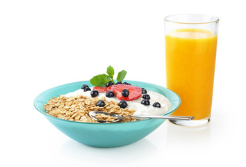 Muesli with fresh berries and yogurt in a bowl isolated on white background.