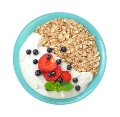 Muesli with fresh berries and yogurt in a bowl isolated on white background.
