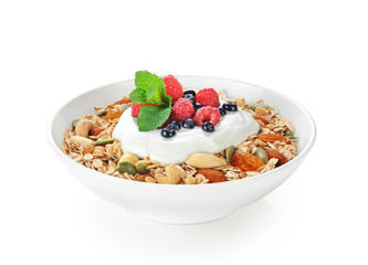 Muesli with fresh berries, nuts and yogurt in a bowl isolated on white background.