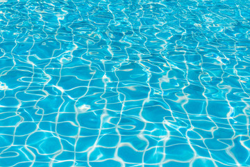 Blue and bright water surface and ripple wave with sun reflection in swimming pool, Blue tile blur in swimming pool for background