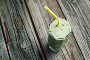 Green smoothie on wooden background