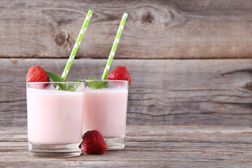 Strawberry yogurt in glass on grey wooden table
