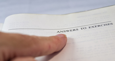 Obraz premium answers to exercises on a school and university textbook with finger