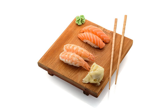 Japanese cuisine. Sushi nigiri with chopsticks on a wooden plate (gete) isolated on white background.