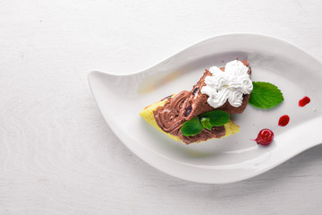Chocolate creamy cream sponge. On a wooden background. Top view. Free space for text.