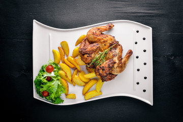 Chicken Grill, Potatoes and Fresh Vegetables. On a wooden background. Top view. Free space for your text.