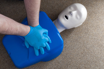 First aid and cardiopulmonary resuscitation training on a CPR dummy, a human shaped doll used to improve the skills and technique of paramedics and first responders