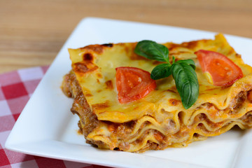 Tasty lasagna served on a wooden table. Closeup.
