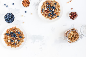 Fototapeta na wymiar Breakfast with muesli, blueberry, nuts on white background. Healthy food concept. Flat lay, top view, copy space
