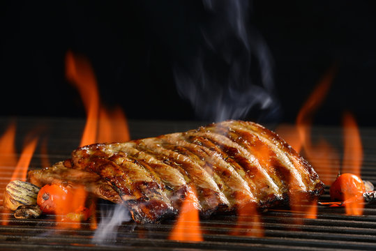  Grilled pork ribs with vegetable on the flaming grill