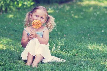 kleines Mädchen mit Zöpfen und Lollipop