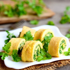Stuffed omelet rolls with cheese and greens on a white plate. Delicious and light egg sushi recipe. Rustic style. Closeup