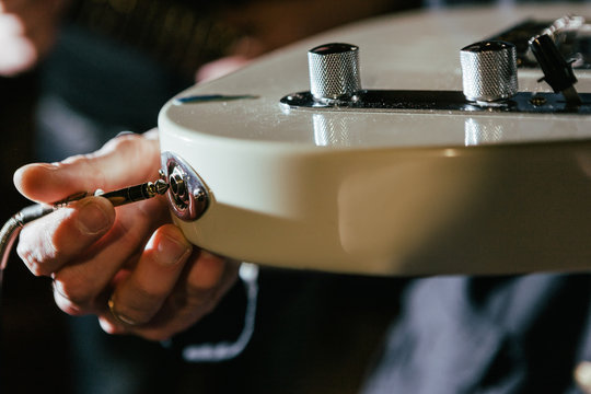 Guitarist connecting guitar in recording studio. Creative hobby for men, rehearsal process, music concept