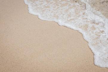 Close up tropical beach with smooth wave and sand texture background.