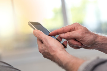 Male hands using smartphone, light effect