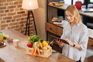 Emotional engaged woman reading vegetarian recipes