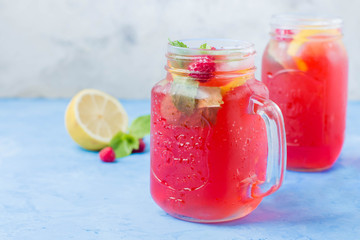 Summer Berry Drink. Lemonade with raspberry lemon, mint in mason jar on blue stone table...