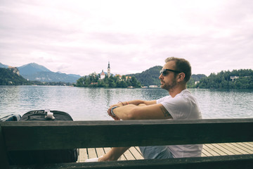 Tourist man sitting on the bench and enjoying on the lake.