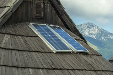 solar photovoltaic panels on wooden mountain house roof