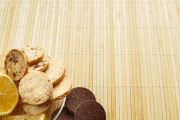 Shortbread cookie with lemon on a light wooden background.