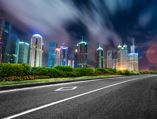 Obraz premium traffic road through modern city at night in Shanghai, China.