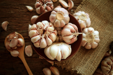 Close up the garlic bulb in bowl on wooden table
