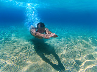 Man swimming underwater in the sea.