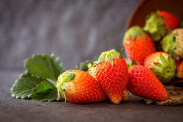 Close up Red Strawberries and leaf with black stone background