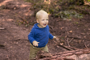 Cute lauginhg baby boy in the autumn forest