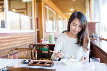 Woman enjoy Japanese barbecue in restaurant