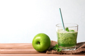  Healthy fresh  green smoothie juice in the glass bottle on wooden table for healthy detox and diet  habits concept