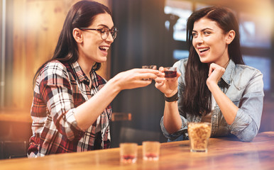 Delighted girls touching their glasses