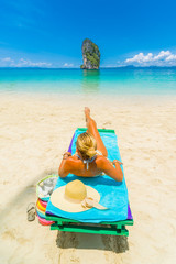 Woman sitting on a bed at the beach