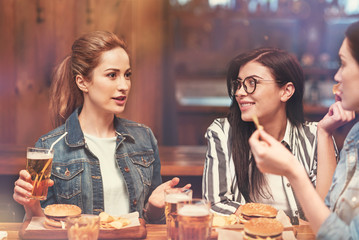 Attractive girl telling funny story to her friends