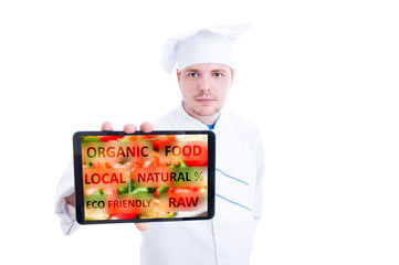 Chef showing digital tablet with vegan food
