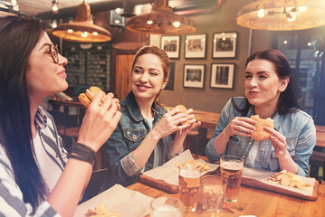 Happy friends eating their burgers