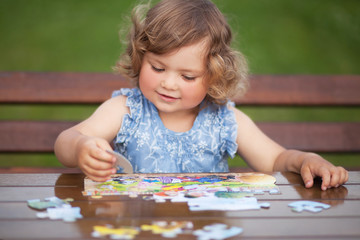 Adorable happy little child playing with puzzle