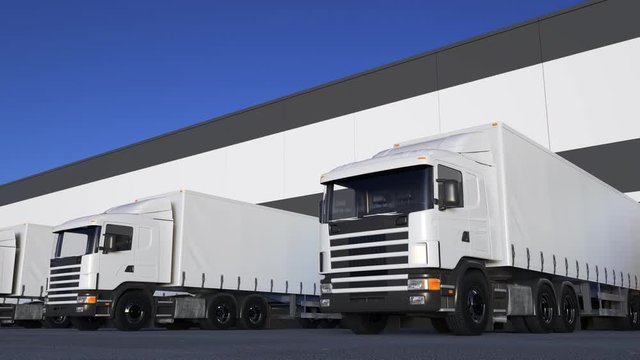 White freight semi trucks loading or unloading. Road cargo transportation. Seamless loop 4K clip